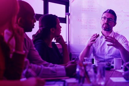 Man talking to a group of people around a table