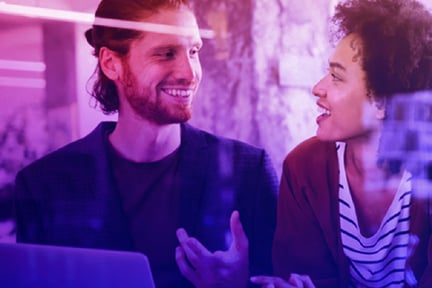 Man talking to woman while on laptop